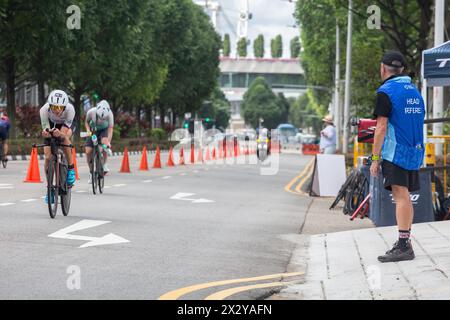 13 avril 2024. Arbitre en chef de triathlon T100 regardant l'athlétisme féminin cyclant sur la route pour une distance de 80 km sous la chaleur. Singapour Banque D'Images