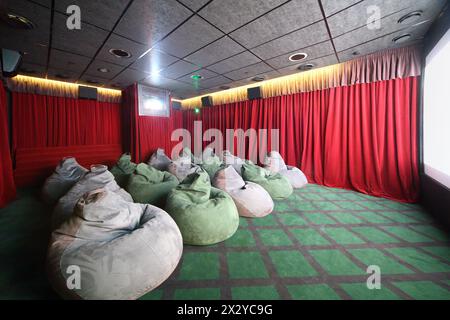 Petite salle de cinéma avec des sièges inhabituels verts confortables et des rideaux rouges. Banque D'Images