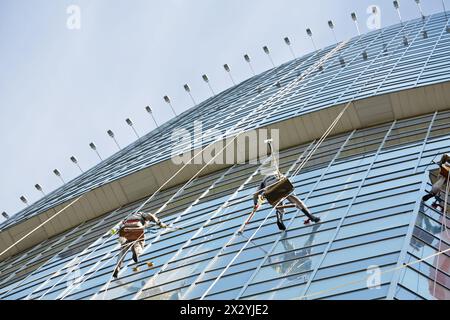 Brigade de nettoyeurs de vitres travaille sur la façade des immeubles de grande hauteur Banque D'Images