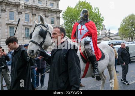 Londres, Royaume-Uni, 23 avril 2024. Un homme habillé en chevalier monte un cheval gris le long de Whitehall. Un rassemblement de la Saint-Georges, en partie une célébration - et en partie une manifestation a été assisté par une grande foule de patriotes, de supporters de football et d'autres, portant des drapeaux rouges et blancs et certains en costume. Crédit : onzième heure photographie/Alamy Live News Banque D'Images