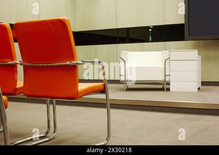 Salle de conférence vide avec fauteuils rouges et blancs Banque D'Images