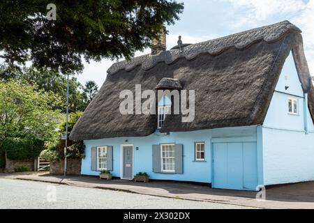 Chalet traditionnel au toit de chaume avec façade bleue et un finial d'un rameur dans un bateau à rames. Great Shelford, Cambridgeshire, Angleterre, Royaume-Uni Banque D'Images