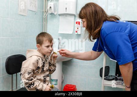 20 avril 2024, Donetsk, Ukraine : un ophtalmologiste de la mission volontaire Frida est vu en train de vérifier la vue d'un enfant FRIDA Ukraine est une mission ukraino-israélienne de volontaires médicaux visant à aider la population civile. Des médecins bénévoles fournissent aux Ukrainiens touchés par les hostilités des médicaments de haute qualité. Ils organisent également des voyages en première ligne des régions désoccupées pour aider les civils qui y vivent. Ce travail bénévole a commencé dans la région de Kiev, suivie par Chernihiv, Sumy, Kharkiv, Mykolaïv, Kherson, Donetsk et d'autres régions où les civils ont de la difficulté à accéder aux soins médicaux c Banque D'Images