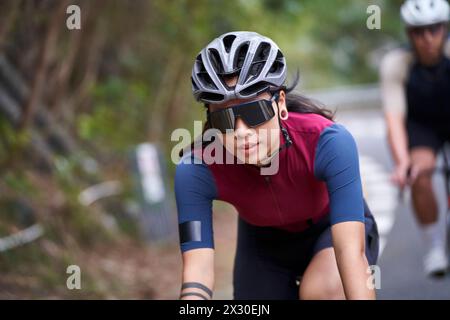 jeune femme asiatique cycliste femme chevauchant le vélo à l'extérieur sur la route rurale Banque D'Images