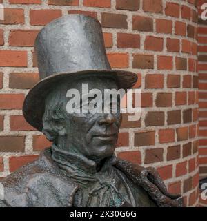 Statue en bronze de H. C. Andersen en chapeau haut de gamme contre un mur de briques rouges, Odense, Danemark, 19 avril 2024 Banque D'Images