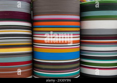 Conteneurs de plantes en plastique multicolores empilés étroitement en rangées pour former un affichage abstrait de couleur et de texture. Banque D'Images