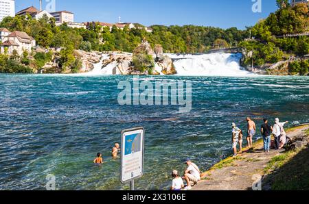 DAS Baden im Rheinfallbecken ist verboten, da wegen der Strömung Lebensgefahr besteht. Einige Touristen wagen sich trotzdem ins Wasser. (Neuhausen am Banque D'Images