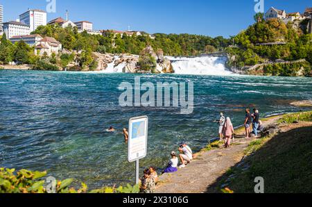 DAS Baden im Rheinfallbecken ist verboten, da wegen der Strömung Lebensgefahr besteht. Einige Touristen wagen sich trotzdem ins Wasser. (Neuhausen am Banque D'Images