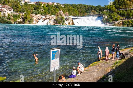 DAS Baden im Rheinfallbecken ist verboten, da wegen der Strömung Lebensgefahr besteht. Einige Touristen wagen sich trotzdem ins Wasser. (Neuhausen am Banque D'Images