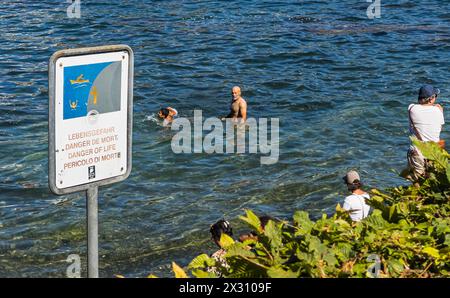 DAS Baden im Rheinfallbecken ist verboten, da wegen der Strömung Lebensgefahr besteht. Einige Touristen wagen sich trotzdem ins Wasser. (Neuhausen am Banque D'Images