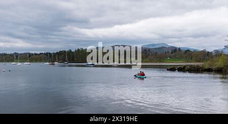 Une vue panoramique sur le lac Windermere à Ambleside avec deux hommes sur un canot Banque D'Images
