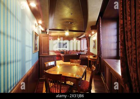 Élégante salle à cigares anglais avec fauteuils et tables en cuir. Banque D'Images