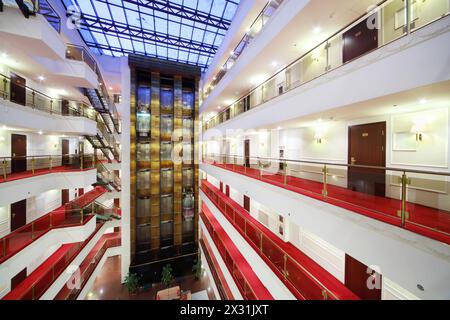 Ascenseurs en verre et planchers avec balcons et de nombreuses portes dans le grand hôtel. Banque D'Images