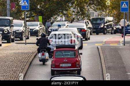VOR einem Fussgängerstreifen in der Stadt Zürich staut sich der Verkehr. Eine Frau überquert den Fussgängerstreifen. (Zürich, Schweiz, 29.10.2022) Banque D'Images