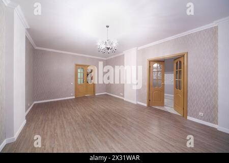 Chambre lumineuse spacieuse avec parquet et portes ouvertes dans un nouvel appartement. Banque D'Images