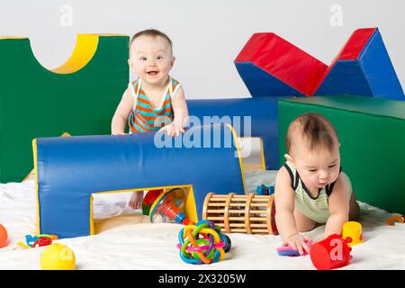 Deux bambins drôles jouent avec des jouets dans le complexe de jeux Banque D'Images