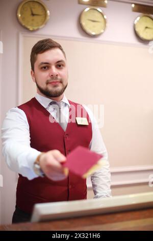 Réceptionniste concierge propose livret dans l'hôtel, hôtel quatre étoiles situé près du parc et est un bâtiment moderne avec des intérieurs élégants. Banque D'Images