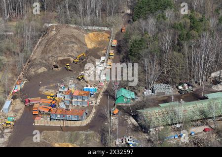 Vue de dessus du petit chantier de construction avec de nombreux camions et machines dans les bois. Banque D'Images