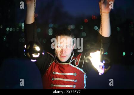 Performance d'un homme avec une terrible pupille en costume de samouraï avec des boules de feu sur la chaîne Banque D'Images