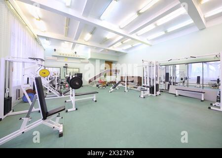 Salle de gym vide spacieuse et bien éclairée avec équipement spécial pour l'entraînement physique Banque D'Images