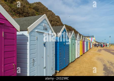 West Cliff Beach. Bournemouth, Royaume-Uni - 12 avril 2024 : cabanes de plage colorées sur la plage. Banque D'Images