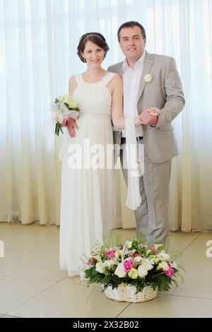 Belle mariée et mariée près d'une grande fenêtre avec des rideaux blancs Banque D'Images