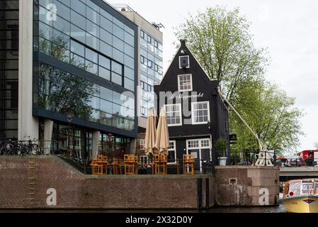 De Sluyswacht café dans une vieille maison tordue à Jodenbreestraat été ici depuis 1685 anciennement gardiens d'écluse chalet vu du bateau de croisière sur le canal Amsterdam Banque D'Images