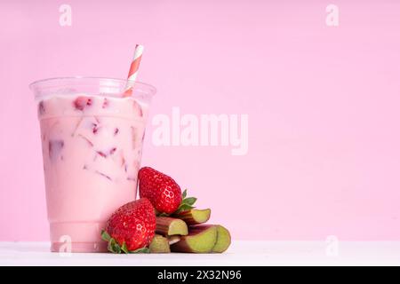 Milkshake à la fraise et à la rhubarbe, cocktail crémeux glacé avec crème glacée fouettée, rhubarbe et fraises tranchées Banque D'Images