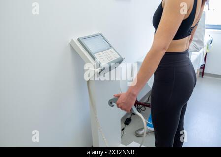 Un praticien de la santé assiste une femme avec un test de composition corporelle à l'aide d'un équipement de pointe. Banque D'Images