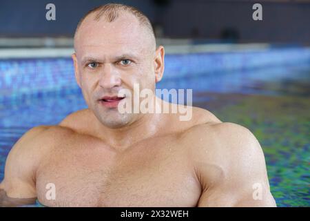 Gros plan de bodybuilder d'âge moyen debout dans la piscine Banque D'Images