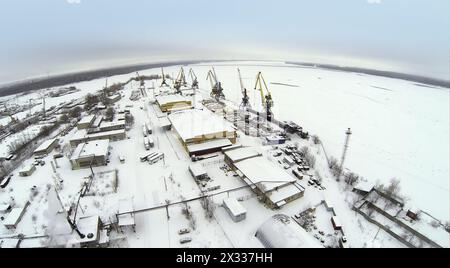 Vue aérienne pour vider le quai de fret avec des grues et des conteneurs sur la rivière gelée Banque D'Images