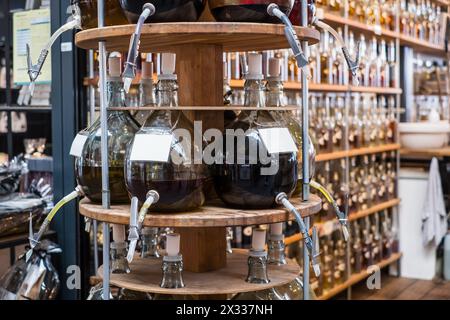 Huiles d'olive et vinaigres balsamiques dans de grands récipients en verre avec un robinet. Banque D'Images