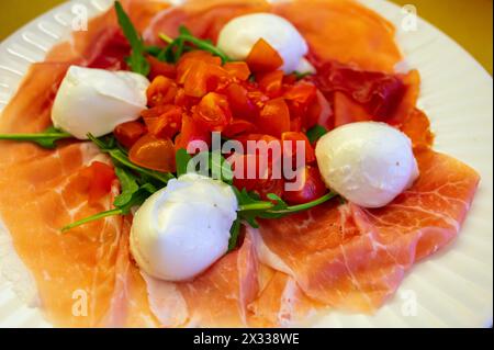 Cuisine de la région Emilie-Romagne, salade Caprese avec Prosciutto crudo, prosciutto di Parma, mozzarella et tomates, déjeuner à Parme, Italie Banque D'Images