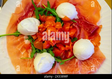 Cuisine de la région Emilie-Romagne, salade Caprese avec Prosciutto crudo, prosciutto di Parma, mozzarella et tomates, déjeuner à Parme, Italie Banque D'Images