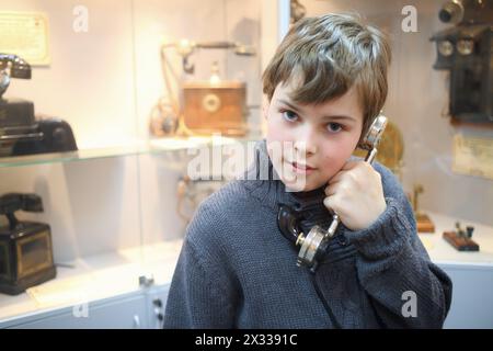 Portrait d'un garçon avec un vieux combiné dans le musée Banque D'Images