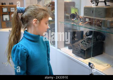 MOSCOU - APR 05, 2014 : fille examine des expositions de téléphone vintage dans le téléphone du Musée de l'histoire à Moscou Banque D'Images
