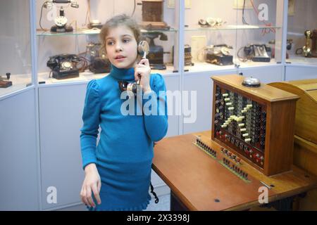 MOSCOU - APR 05, 2014 : fille dans une veste bleue avec un vieux combiné dans le téléphone du Musée de l'histoire à Moscou Banque D'Images