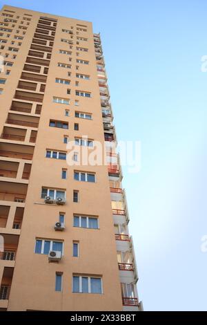 bâtiment de plusieurs étages avec fenêtres, balcons et climatisation sur fond de ciel bleu Banque D'Images