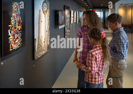 USA, NEW YORK - 25 août 2014 : femme et deux enfants (modèles avec autorisations) regardent des photos et des images dans le bureau principal de Shutterstock. Banque D'Images