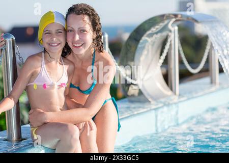 mère et fille assis sur le bord de la piscine sur le toit Banque D'Images