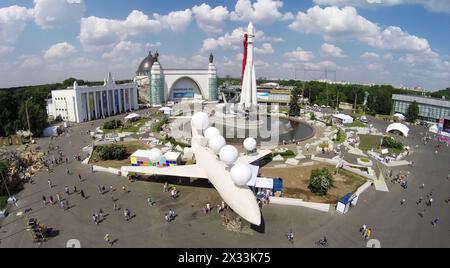 RUSSIE, MOSCOU - 24 MAI 2014 : les gens marchent par la place industrielle avec le monument de l'avion et la fusée spatiale sur le territoire de toute la Russie centre d'exposition Banque D'Images