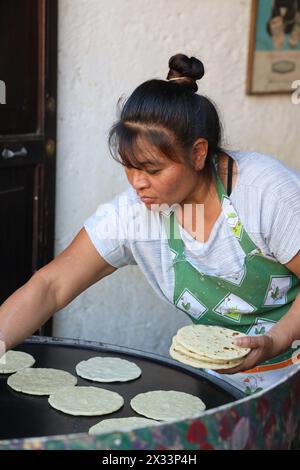 Femme guatémaltèque fabriquant et cuisinant des tortillas traditionnelles. Antigua, Guatemala, Amérique centrale. Tortillas de maïs faites à la main -dos o tres Veces CADA dia Banque D'Images