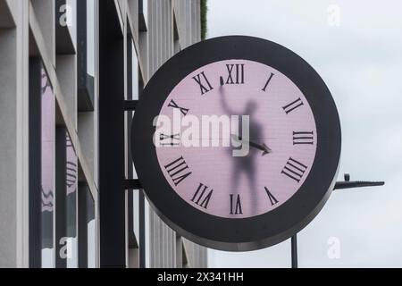 Londres, Royaume-Uni. 24 avril 2024. Un ouvrier semble nettoyer l'intérieur d'une grande horloge sur le côté d'un immeuble de bureaux à Paddington. Une inspection plus approfondie révèle qu'il s'agit d'une image générée par ordinateur où le personnage animé continue de nettoyer puis de redessiner les aiguilles de l'horloge pour révéler l'heure correcte. Credit : Stephen Chung / Alamy Live News Banque D'Images