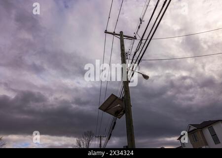 Vue rapprochée de lignes électriques à haute tension fonctionnant sur des poteaux en bois le long d'une rue dans le New Jersey. ÉTATS-UNIS. Banque D'Images