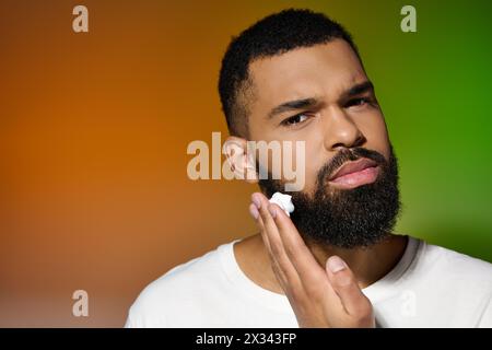 Homme afro-américain attrayant tient la crème à raser. Banque D'Images