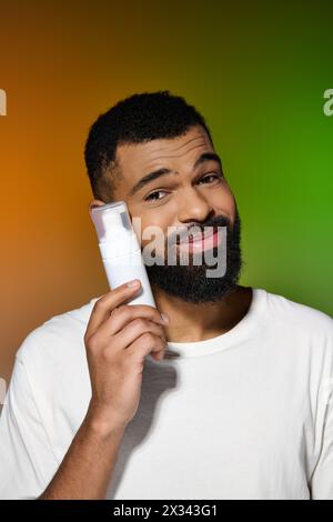 Afro-américain bel homme tient la crème à raser. Banque D'Images