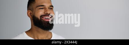 Un homme barbu en blanc, souriant chaleureusement. Banque D'Images