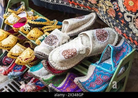 Un assortiment de chaussons en feutre ouzbek décorés est exposé dans un bazar de rue à Boukhara Banque D'Images