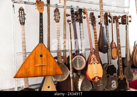 Une variété d'instruments de musique asiatiques à cordes sont mis en vente dans un bazar à Boukhara Banque D'Images