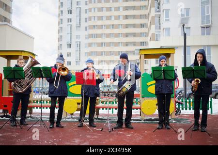 Brass band de six musiciens jouent en plein air lors de la froide journée d'hiver sur le terrain de jeu Banque D'Images